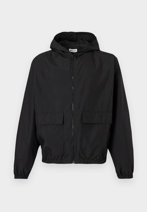 Veste légère noire à capuche avec fermeture éclair à l'avant, deux grandes poches à rabat, poignets élastiques et ourlet élastique.