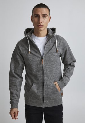 Gray zip-up hoodie with a front pocket, drawstring hood, and ribbed cuffs. Features a smooth texture and a small leather label at the hem.