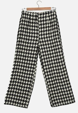 Kalhoty s černobílým houndstooth vzorem, volného střihu, vyrobené z texturované látky, se bočními švy a pasem.