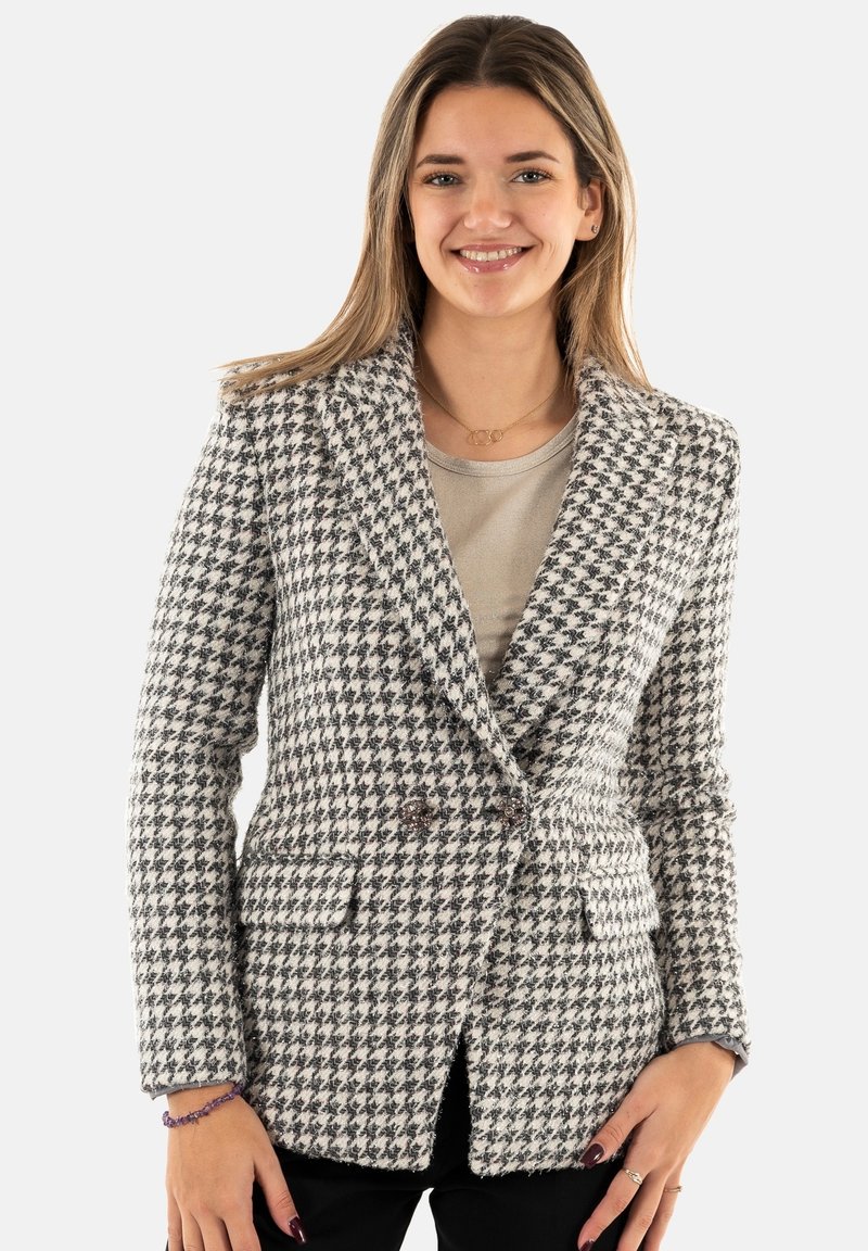 Blazer houndstooth in bianco e nero, tessuto texturizzato, vestibilità su misura, design doppiopetto, rever a punta, con tasche frontali.