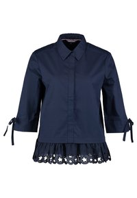 Marinblå skjorta med krage, trekvartslånga ärmar och slipsdetaljer. Nedtill har den en volangdesign med stjärnformade utskärningar.