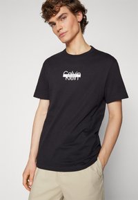 Calvin Klein CUT THROUGH LOGO - Apdrukāts T-krekls - black