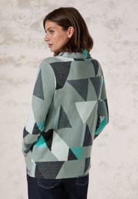 Mehrfarbiger Pullover mit einem geometrischen Muster aus Dreiecken in Mintgrün, Anthrazit und Schwarz, mit einer weichen Textur und einem Kragen.