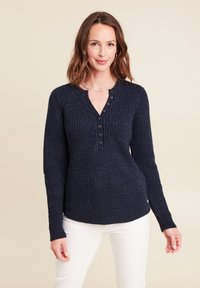 Marineblauer Strickpullover mit strukturiertem Design, Knopfleiste und langen Ärmeln. Der Stoff hat einen dezenten Schimmer, der einen lässigen Look unterstreicht.