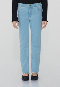 Světle modré džíny s rovný střih, s předními kapsami, zapínáním na knoflík a potrhanými lemy. Oblékané s černými balerínami.