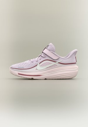 Jasnoróżowy but do biegania Nike z siateczkową cholewką, paskiem na rzep, amortyzowaną podeszwą i białym logo Swoosh po boku na neutralnym tle.