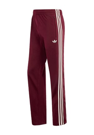 Bordo spalvos sportinės kelnės iš minkšto audinio, su baltomis trimis juostelėmis šonuose ir užtrauktuku užsegama kišene ant kairės kojos.