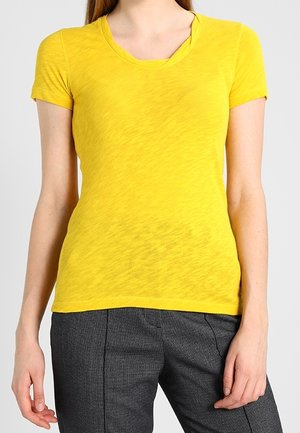 T-shirt gialla a maniche corte con scollo rotondo, realizzata in tessuto leggero. Finitura texturizzata e leggermente trasparente con una vestibilità comoda.