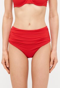 Rød højhvidet bikiniunderdel lavet af glat stof, med en samlet struktur ved taljen og et tætsiddende design.