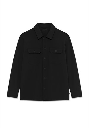 Fekete, hosszú ujjú, gombos ing gallérral és két elülső, gombbal zárt zsebbel, fehér háttéren laposan elhelyezve.