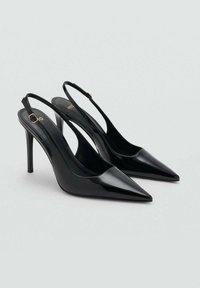 Čierne lakované slingback podpätky s špicatými špičkami a tenkými podpätkami, s detailom zlatého tónu na remienku okolo členku.