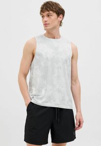 Grå ærmeløs sportstop med et subtilt mønster, parret med sorte shorts. Toppen har rund halsudskæring og logodetalje på brystet.