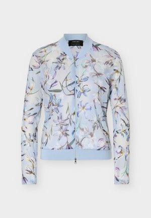 Blouson aviateur bleu clair à fermeture éclair, avec col et poignets côtelés, présentant un délicat motif floral multicolore sur un tissu transparent.