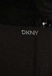Vestido negro con detalles de lentejuelas en la parte superior. Presenta un logotipo brillante de DKNY creado con rhinestones, tejido texturizado y una silueta ajustada.