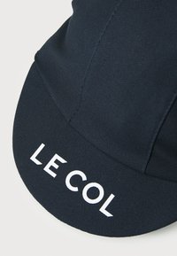 Navy Radmütze aus strukturiertem Stoff, mit einem gebogenen Schirm und dem Text "LE COL" in Weiß. Präsentiert ein schlankes, minimalistisches Design.