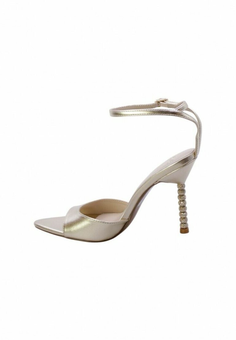 Sandaletta alta in metallo dorato con punta quadrata, cinturino per la caviglia e tacco decorativo ricoperto di cristalli. Texture liscia, design minimalista.