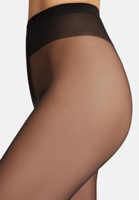 Genomskinliga bruna strumpbyxor med en mjuk textur. Hög midja med svart elastiskt midjeband, vilket ger ett sömlöst utseende på benet.