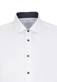 Camicia bianca slim-fit con colletto strutturato, dettagli in bottoni scuri e motivo a pois all'interno del colletto. Design perfettamente sartoriale.
