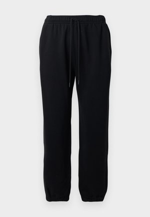 Pantalons de survêtement noirs avec une taille élastique et un cordon de serrage. Tissu doux avec des poignets élastiques au niveau des chevilles. Aucun motif ni élément en métal visible.