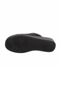 Suola di scarpa in gomma nera con superficie tessurizzata ed elementi di design circolari. Presenta un tacco leggero e motivi rigati per una migliore aderenza.