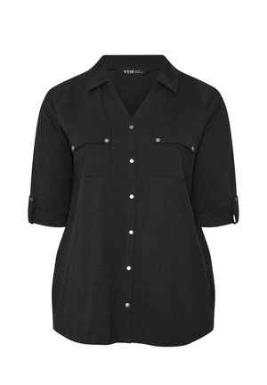 Camicia nera con colletto a V, maniche corte arrotolate, due tasche frontali e bottoni a pressione in argento. Tessuto morbido e leggero.