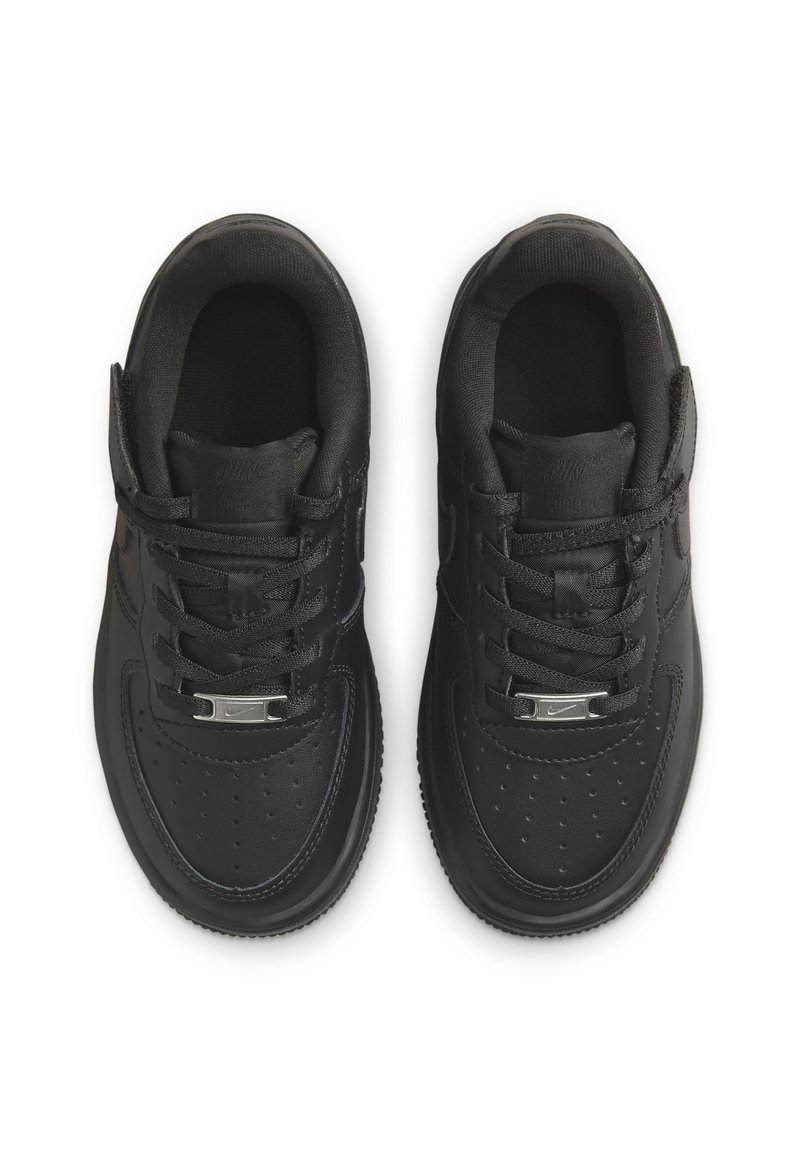 Des baskets noires avec une tige en cuir lisse, un laçage, une boîte à orteils perforée et des éléments en métal argenté sur la languette. Semelle en caoutchouc arrondie.