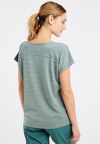 Korte mouwen, ontspannen pasvorm shirt in een zachte, gestructureerde groene stof. Heeft een ronde halslijn en een naadloos ontwerp aan de achterkant.