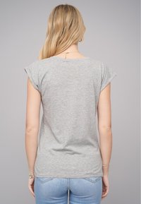 T-shirt gris à manches courtes avec une coupe décontractée, fabriqué en coton doux, doté d'un col rond et de détails de couture subtils à l'ourlet.