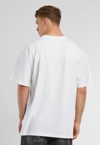 White cotton t-shirt with a relaxed fit, short sleeves, and a crew neck, featuring a smooth texture and no visible logos or embellishments.
