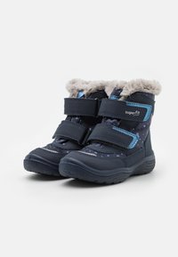 Botas para niños de color azul marino con borde de piel gris, dos correas de velcro ajustables y un patrón de lunares sobre una superficie texturizada.
