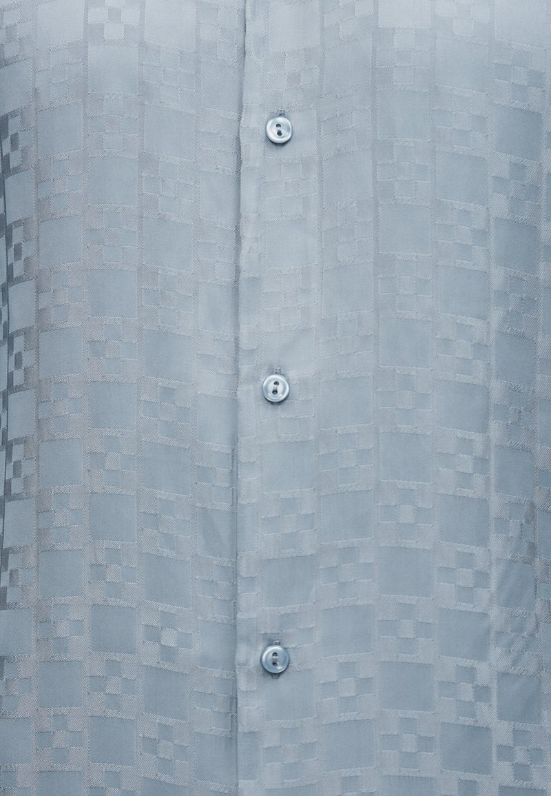 Light blue fabric with subtle checkered pattern, featuring a vertical row of small translucent buttons.