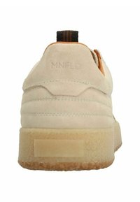 Sneaker in suede beige con retro testurizzato e cuciture orizzontali, un pull tab marrone e nero, e una suola in gomma chiara.