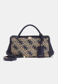 Sac à main rectangulaire beige et bleu marine avec motif logo répétitif, fermoir doré, poignées supérieures, bandoulière amovible et étiquette « GUESS ».