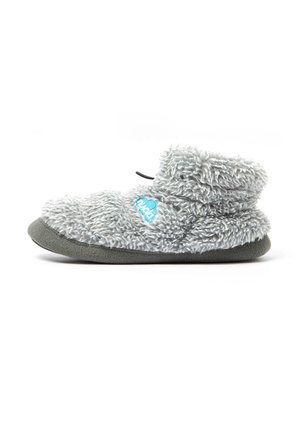 Zapatilla suave, gris y peluda con altura hasta el tobillo y suela oscura, con un logo azul en el lateral y una lengüeta negra en la parte trasera.