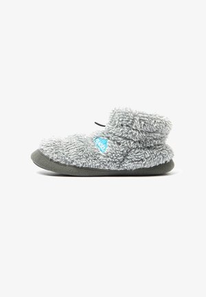 Zapatilla suave, gris y peluda con altura hasta el tobillo y suela oscura, con un logo azul en el lateral y una lengüeta negra en la parte trasera.