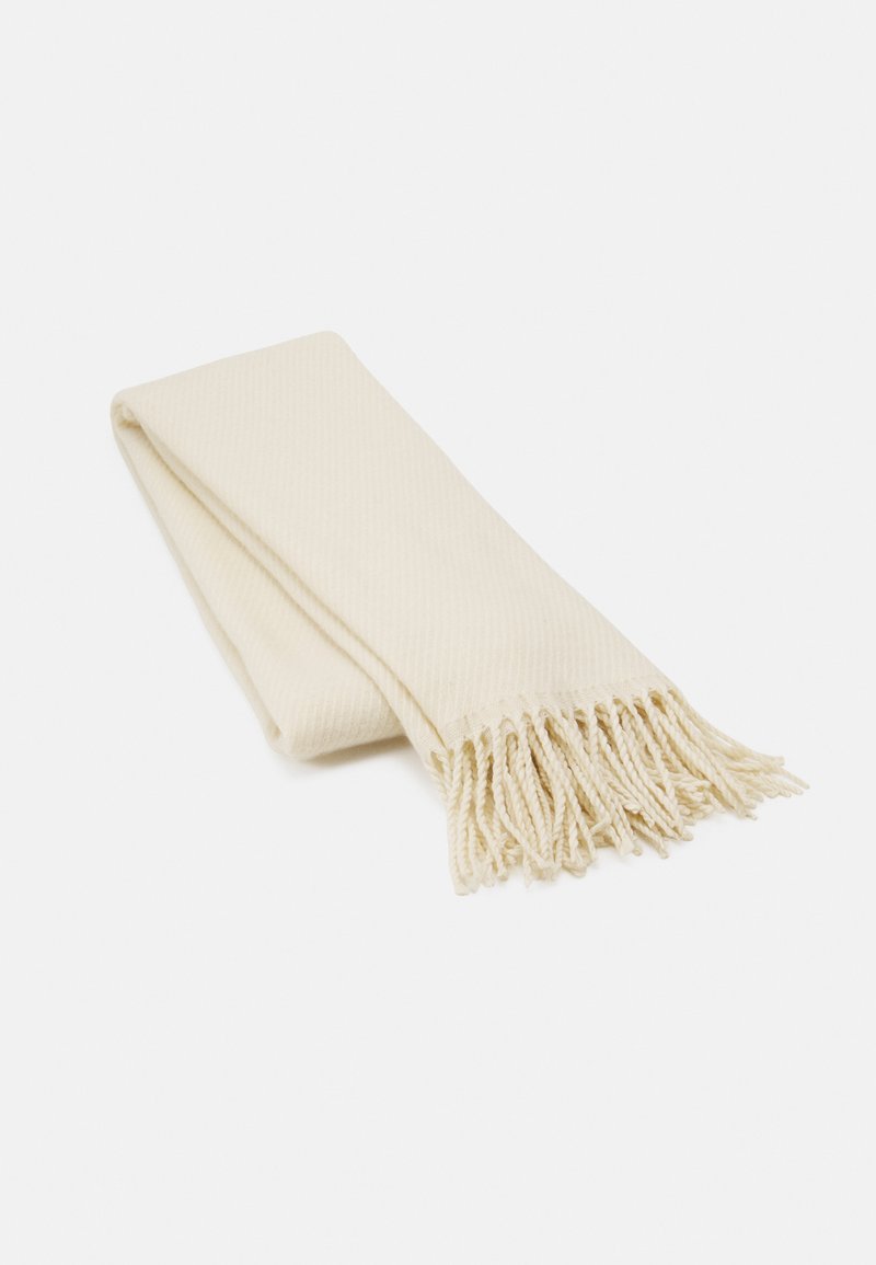 Cachecol tricotado em cor creme com um padrão texturizado, apresentando bordas com franjas. O cachecol está dobrado de forma ordenada.