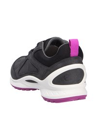 Sneaker nera con materiale testurizzato, soletta bianca e accento viola sul tallone. Presenta una tomaia in rete e un linguetta per il rilascio.