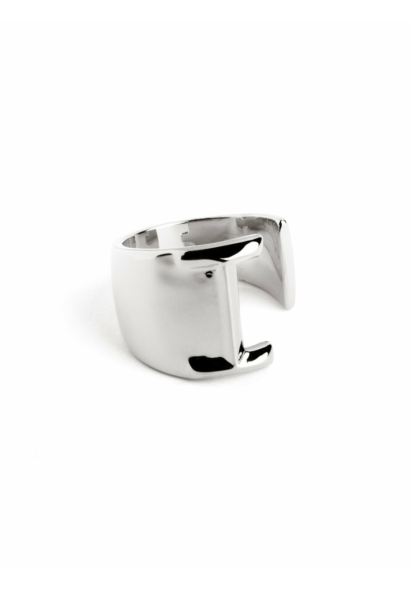 Anello in metallo tono argento, banda larga con finitura lucida e liscia. Presenta un design a ritaglio unico su un lato, creando una forma geometrica moderna.