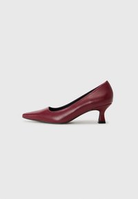 Décolleté in pelle bordeaux con punta affusolata, tacco basso e texture liscia. Il design presenta un leggero taglio sulla tomaia.