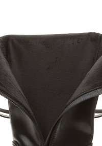 Bota de cuero negra con forro suave de felpa en el interior, parcialmente desabrochada para mostrar el forro y el exterior de cuero.