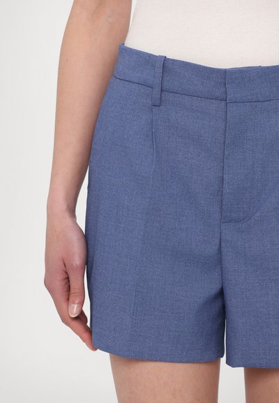 Siniset shortsit, joissa on sileä pinta, litteä etuosa, vyölenkit ja sivutaskut. Valmistettu kevyestä kudotusta kankaasta.