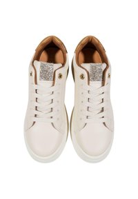 Zapatillas de cuero blancas con una textura suave, que presentan un brillante acento plateado en la lengua y un forro interior beige.