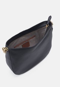 Czarna skórzana torba o gładkiej fakturze, z złotymi akcesoriami i wewnętrzną kieszenią na karty. Projekt jest funkcjonalny z górnym zamkiem błyskawicznym.
