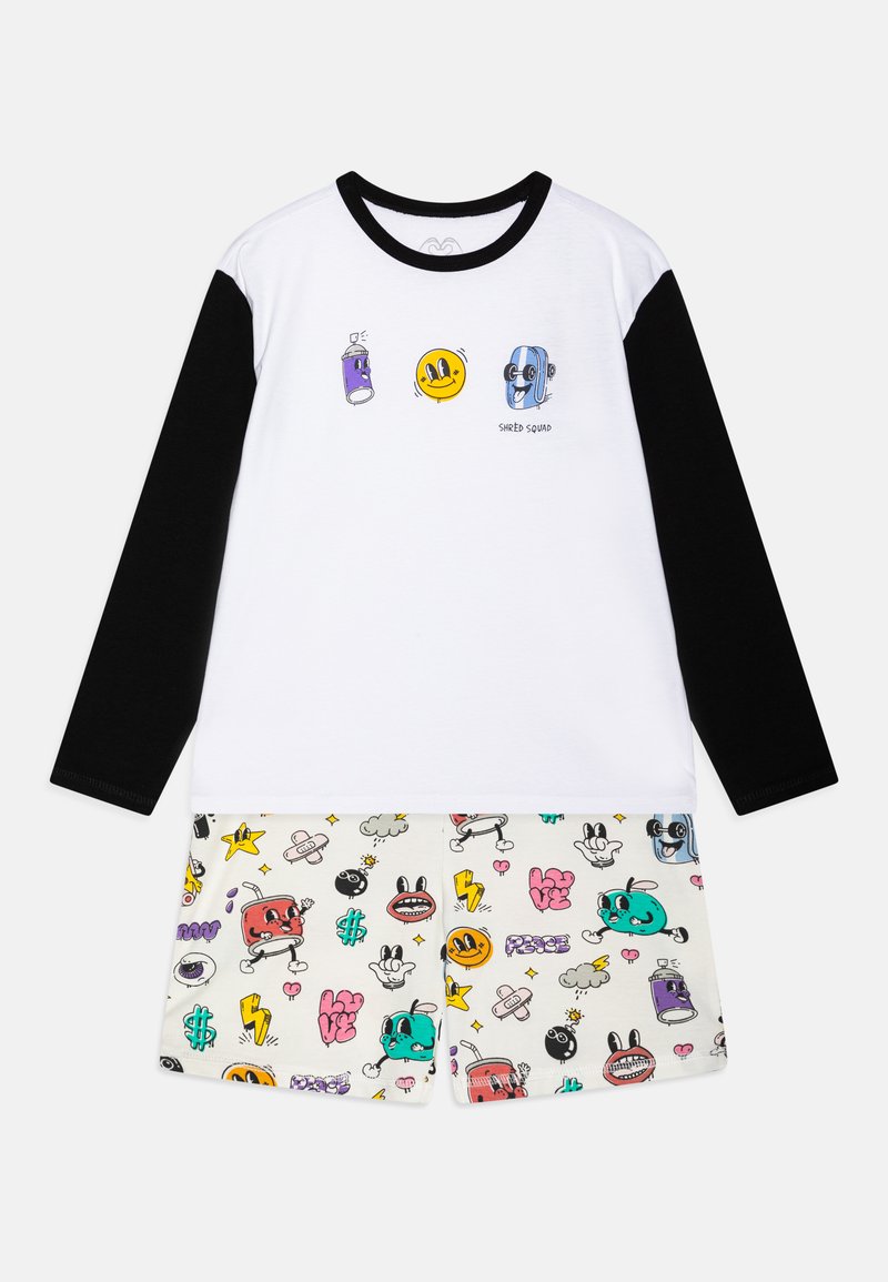 Weißes und schwarzes Langarmhemd mit Cartoon-Grafiken; cremefarbene Shorts mit bunten Mustern von Gesichtern und Symbolen; weicher Baumwollstoff.