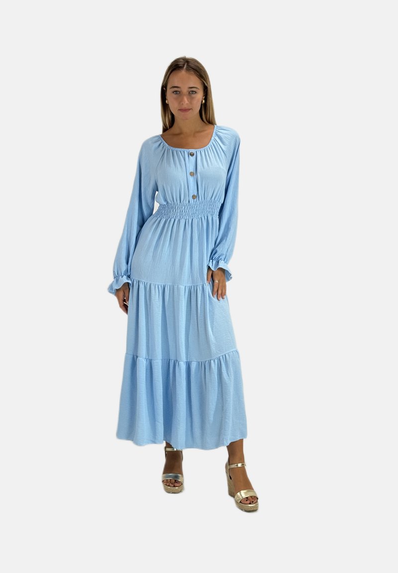 Abito lungo a maniche lunghe di colore azzurro chiaro con corpetto arricciato, gonna a strati e dettaglio di bottoni al colletto. Tessuto morbido con un design fluido.