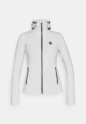 Jachetă albă cu fermoar, cu un design ajustat, guler înalt și fermoare negre. Are un logo pe partea stângă a pieptului și mâneci lungi.