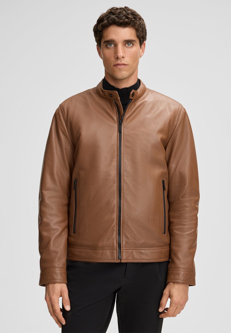 Bruine leren jas met een staande kraag, rits aan de voorkant en twee zijritszakken. Glad textuur met minimale stikdetails.