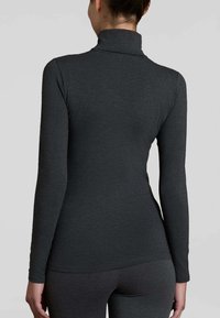 Maglione a maniche lunghe con collo alto in tessuto grigio scuro, che mette in mostra un design aderente, una texture liscia e uno stile minimalista senza hardware visibile.