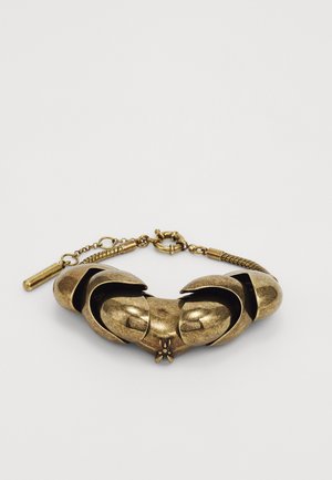 Bronzas rokassprādze, kas veidota kā savijušās naglas, ar teksturētu virsmu, dekoratīvu insektu izstrādājumu un ķēdes sprādzi.