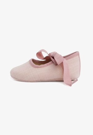 Ballerines en textile rose clair avec une surface texturée, bout rond, et un ruban en satin noué à la cheville pour une touche supplémentaire.